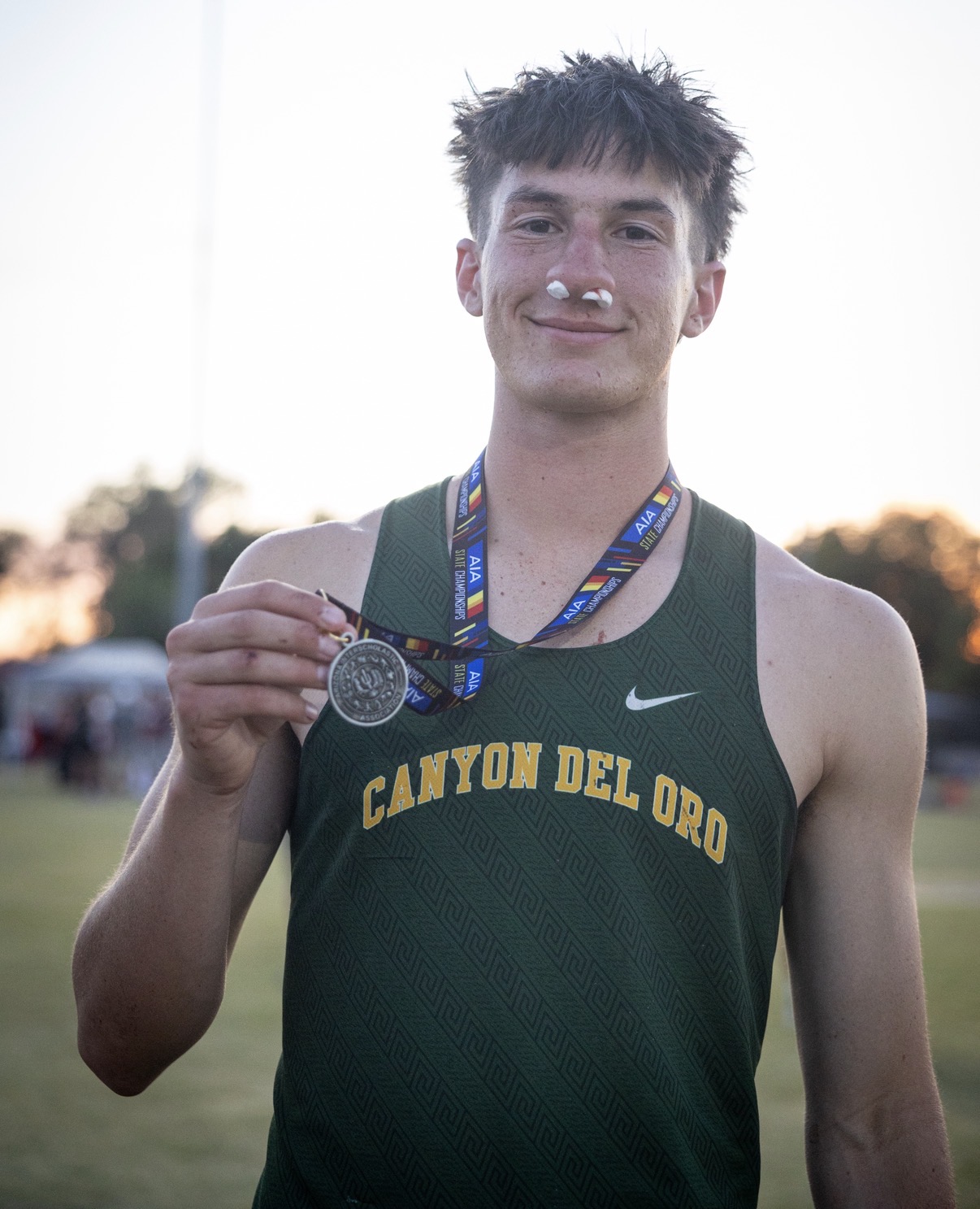 Zach N. holding his medal after the Arizona state meet
